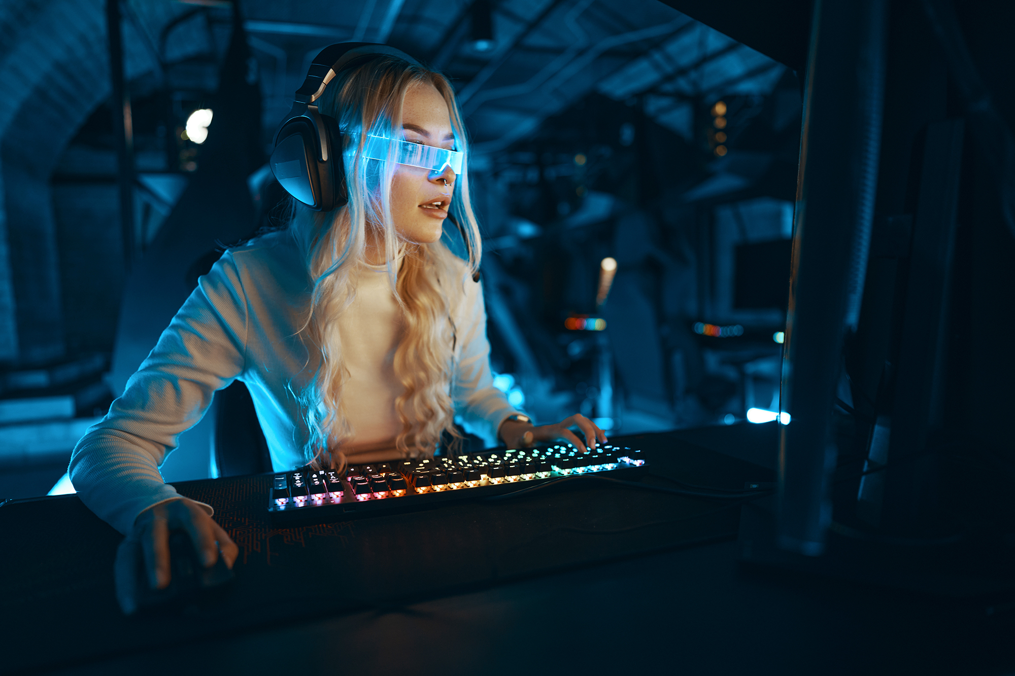 Blonde in cyberpunk glasses plays computer games, fascinated by technology and the virtual world. High quality photo